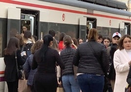 Unos viajeros intentan acceder al tren en Alfafar.