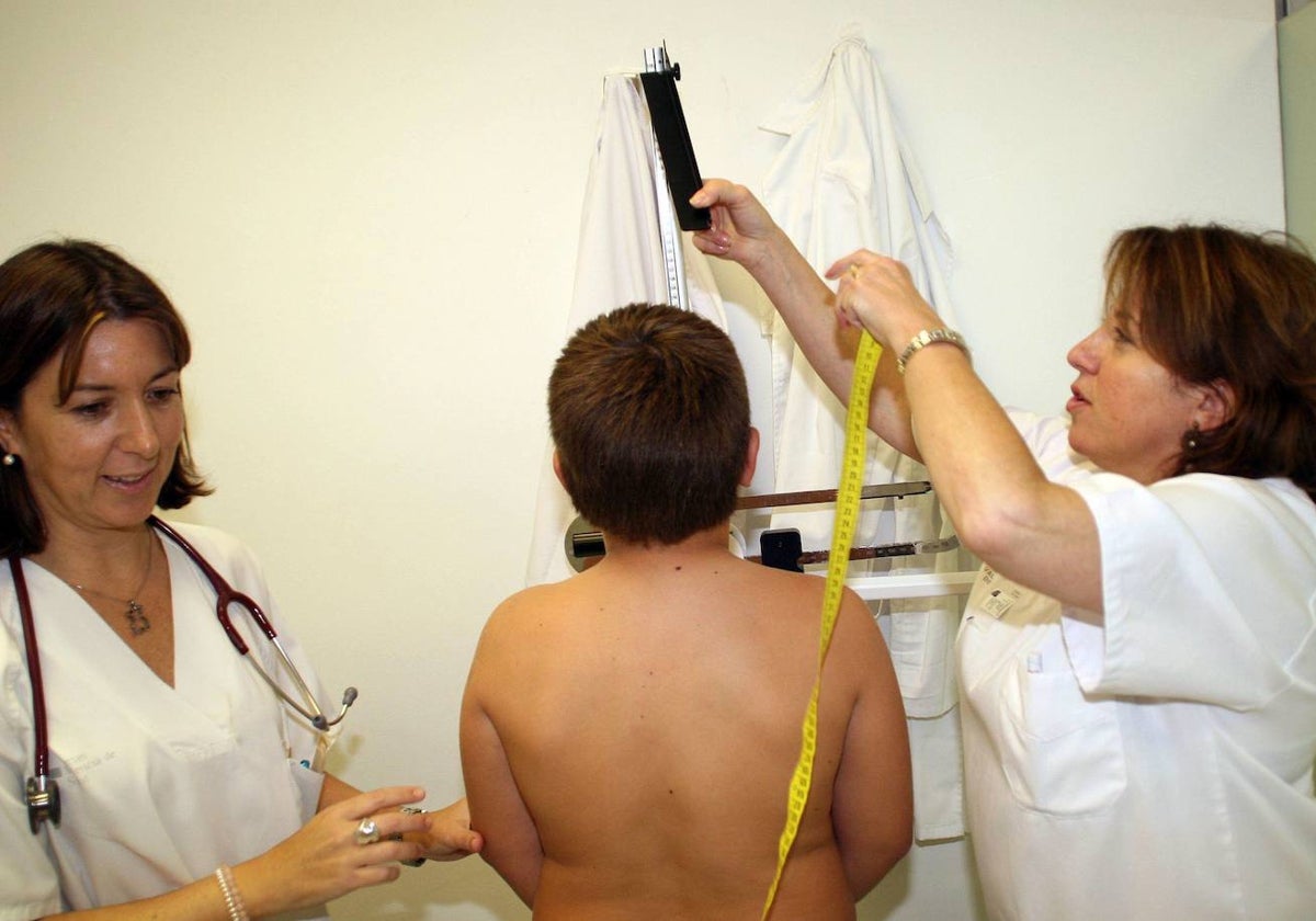 Una médico y una enfermera con un niño en la consulta.