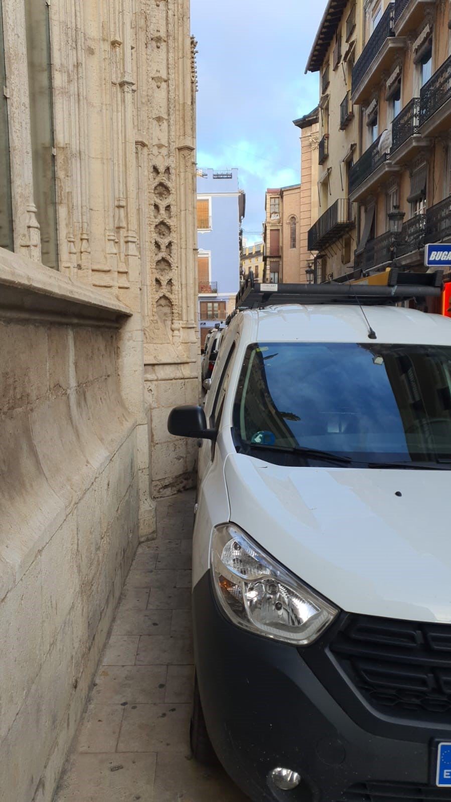 Una furgoneta, aparcada casi tocando uno de los muros de la Lonja de Valencia.