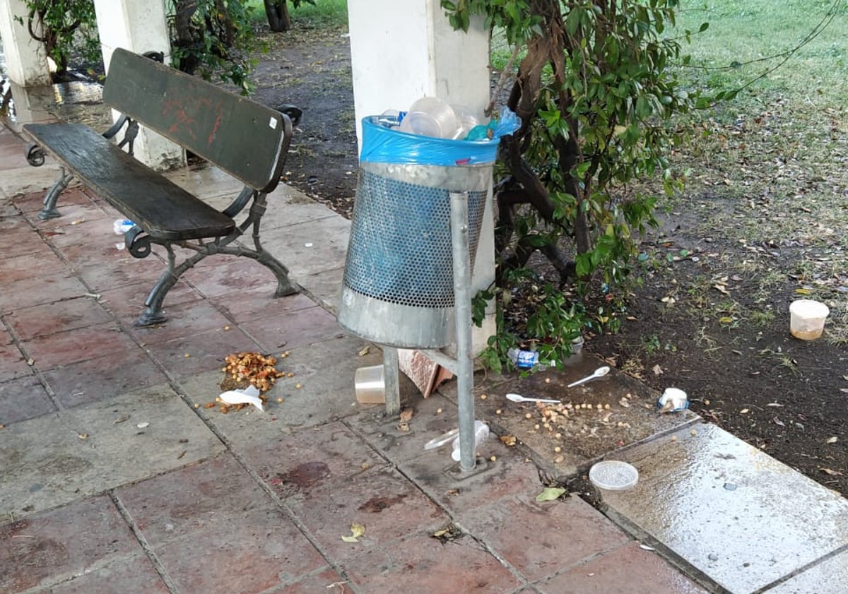 Imagen principal - Restos de suciedad en el Jardín del Turia tras el reparto de alimentos.