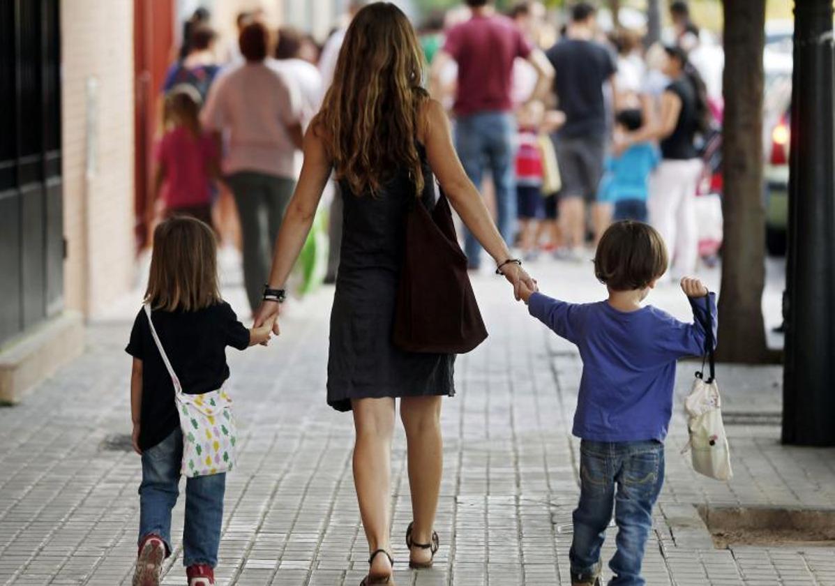 Una madre acompaña a sus hijos al colegio en el primer día de clase, en una imagen de archivo.