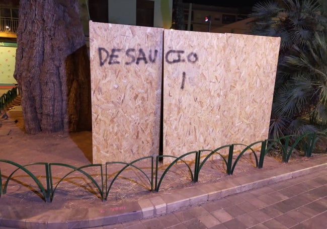 Grafiti con falta de ortografía incluida, en los tablones de madera que custodian por la noche el belén de Benimaclet.