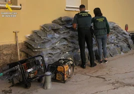 Dos agentes junto a la marihuana confiscada.