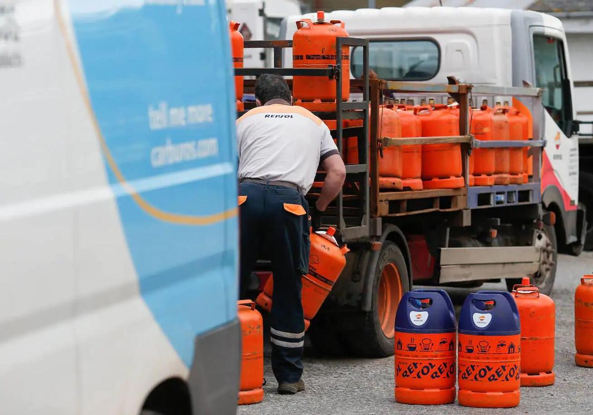 Un repartidor carga con una bombona de butano.