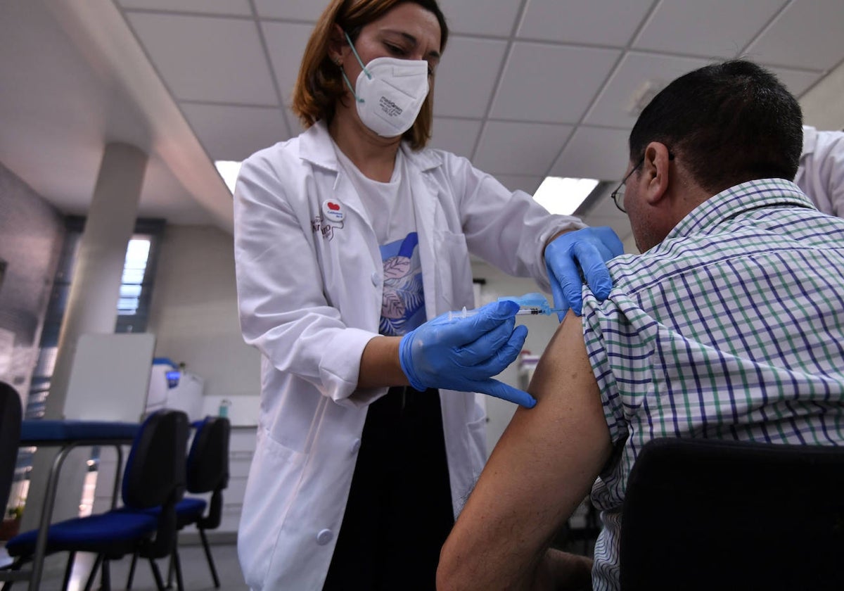 Una sanitaria administra la vacuna a un paciente.