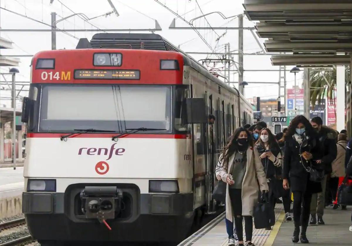 Viajeros junto a un tren de Cercanías en la estación del Norte de Valencia.