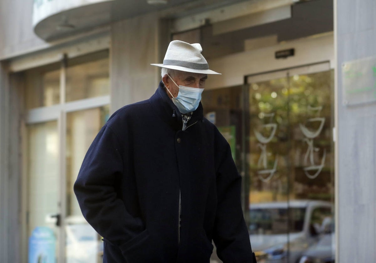 Un hombre camina con su mascarilla por Valencia.