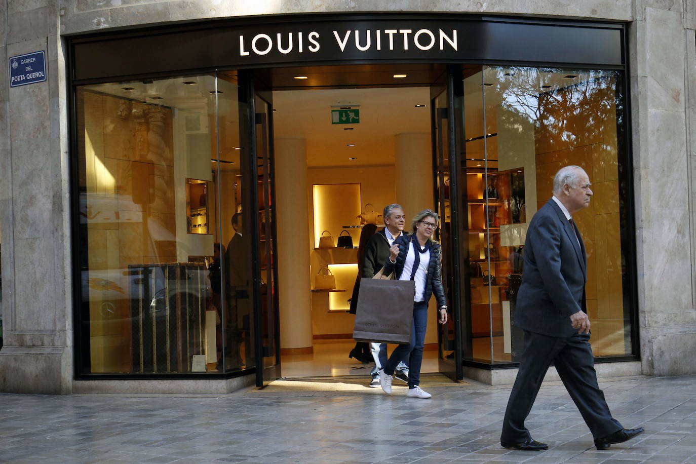 Una pareja sale de la antigua tienda de Louis Vuitton en Valencia con una bolsa sin logo, en una fotografía de 2016.