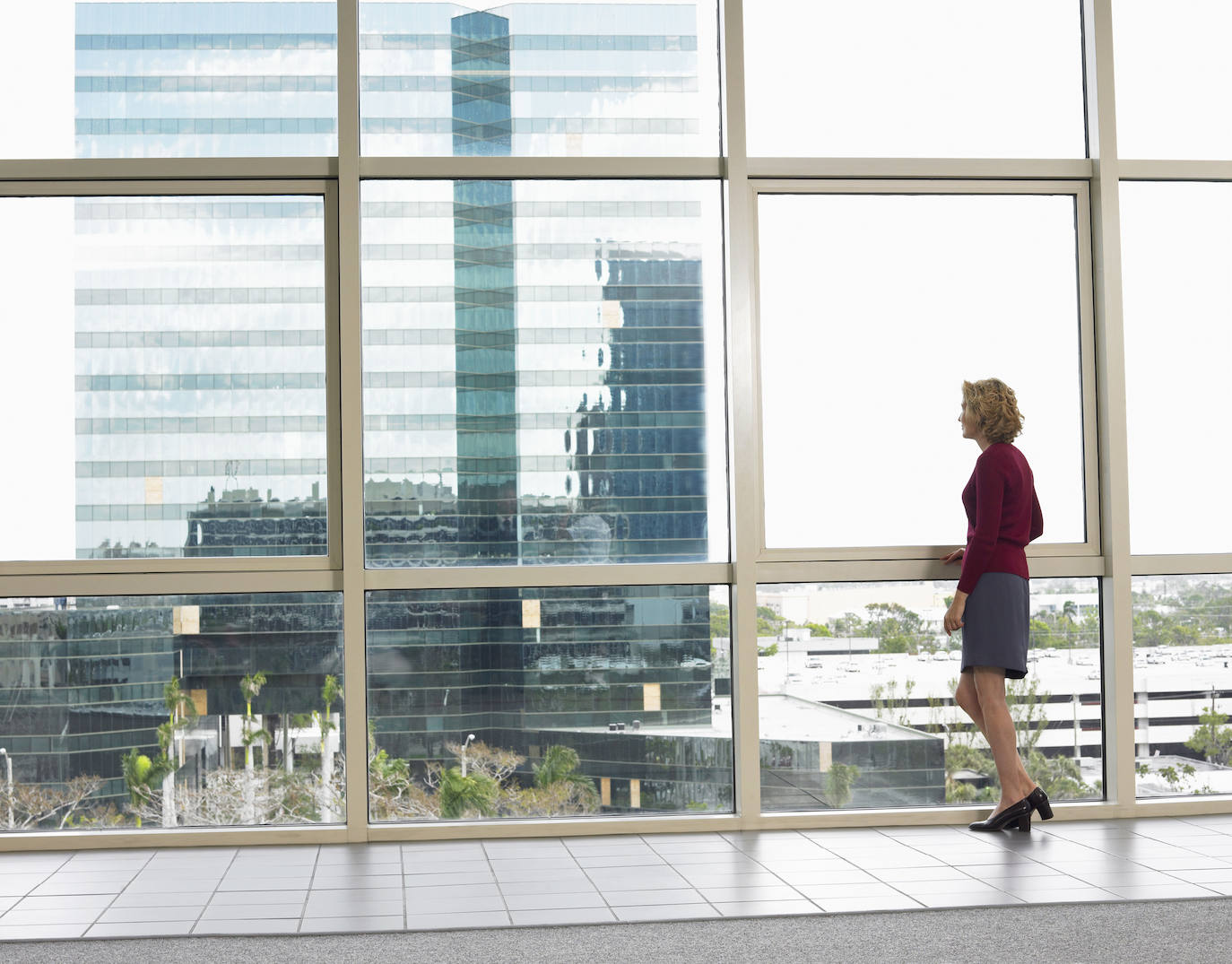 Una mujer mira por la ventana desde su lugar de trabajo.