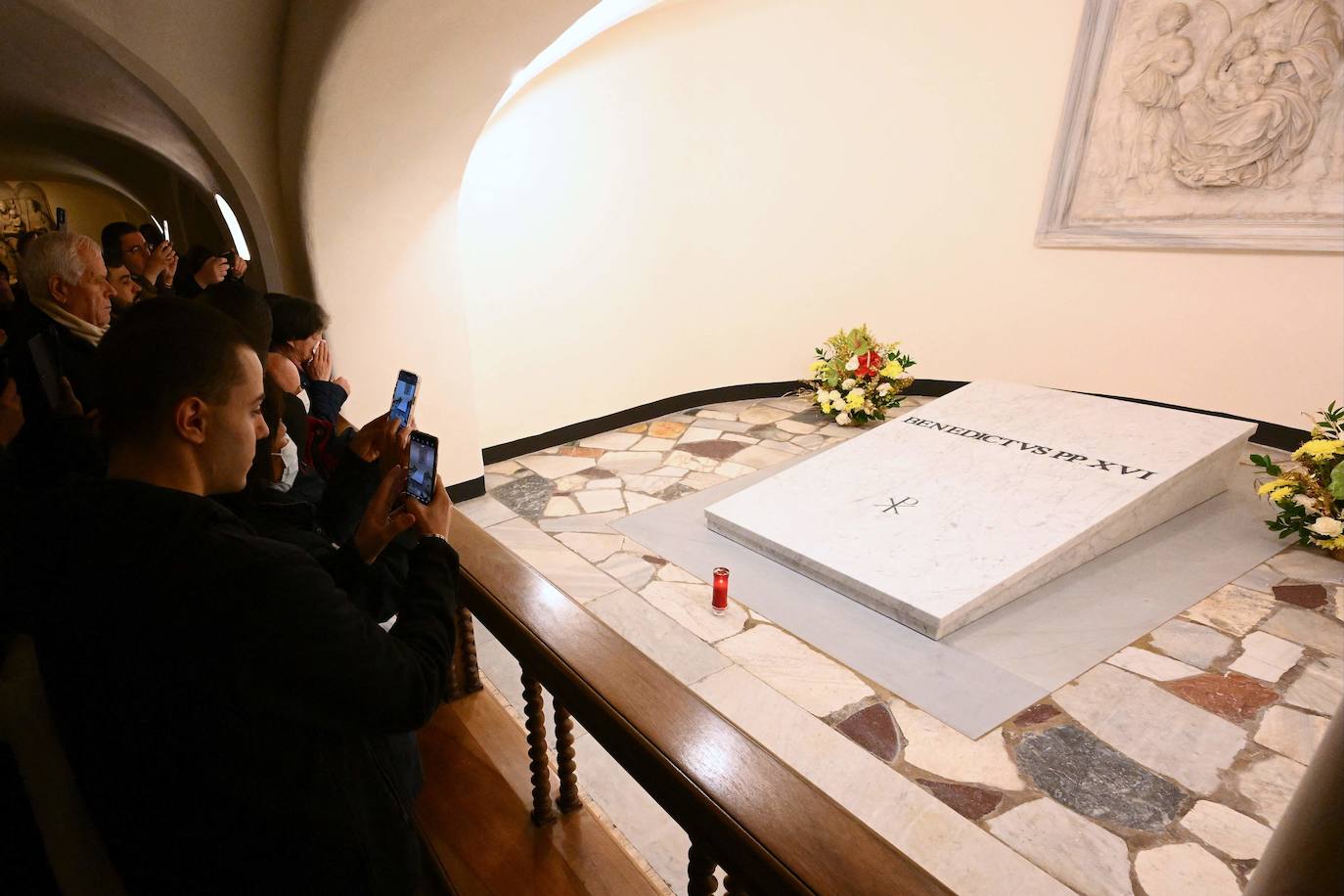 Tal y como estaba previsto, después de las obras efectuadas para la introducción en la cripta del ataúd, las puertas de este área situada en los sótanos de la basílica de San Pedro han reabierto de nuevo a los turistas y los fieles. Los restos mortales de Benedicto XVI, que reposan en un ataúd triple, el primero elaborado con madera de ciprés, el segundo de zinc y el tercero de roble, junto con algunos objetos personales, como las medallas acuñadas durante su pontificado o un pergamino con los hechos más destacados de su vida como la lucha contra los abusos sexuales, fueron trasladados este jueves hasta las grutas vaticanas después de su funeral oficiado por el Papa Francisco en la plaza de San Pedro del Vaticano.