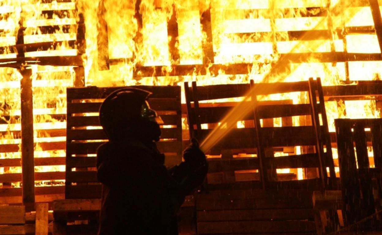 Los bomberos apagan una de las hogueras. 