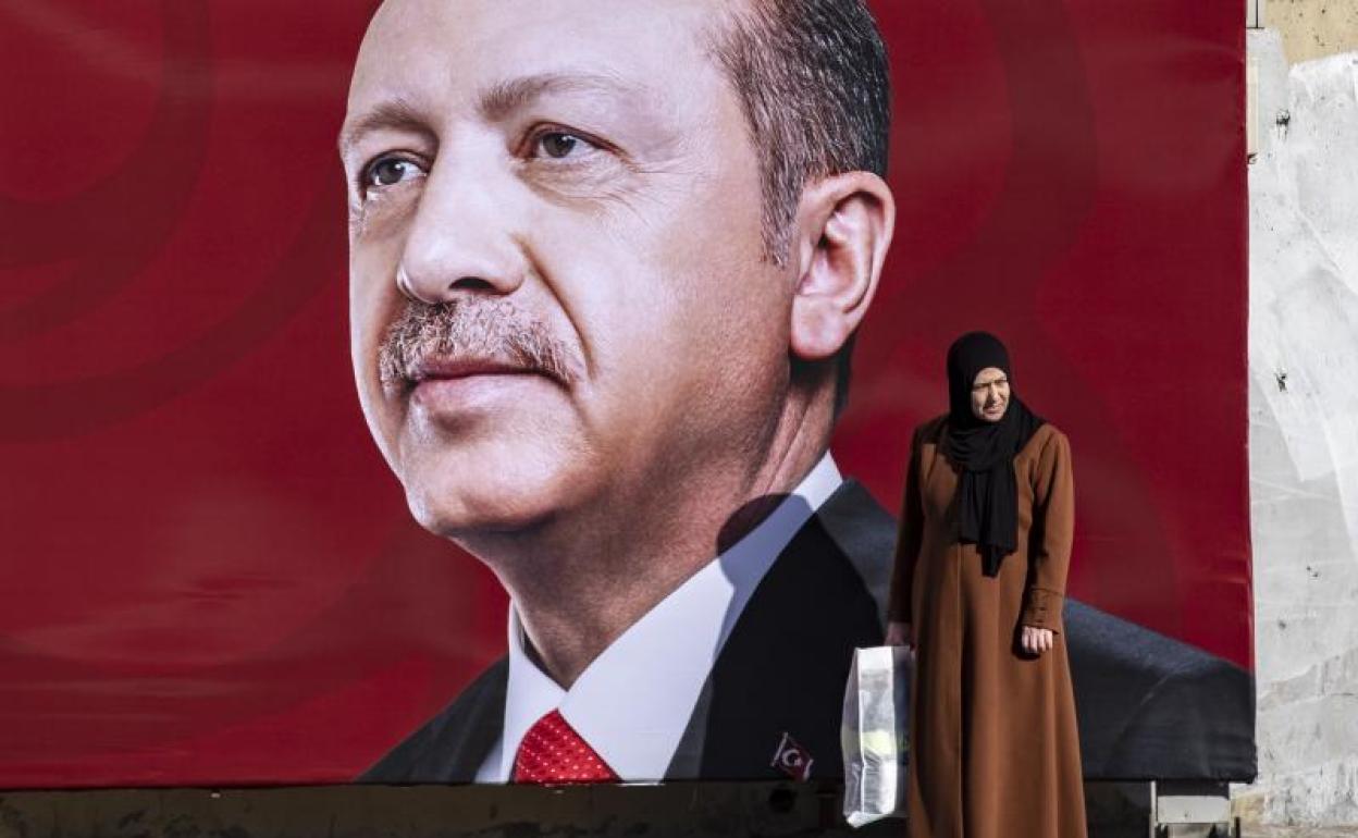 Una mujer con velo se detiene ante una fotografía del presidente turco, Recep Tayyip Erdogan, en Estambul.