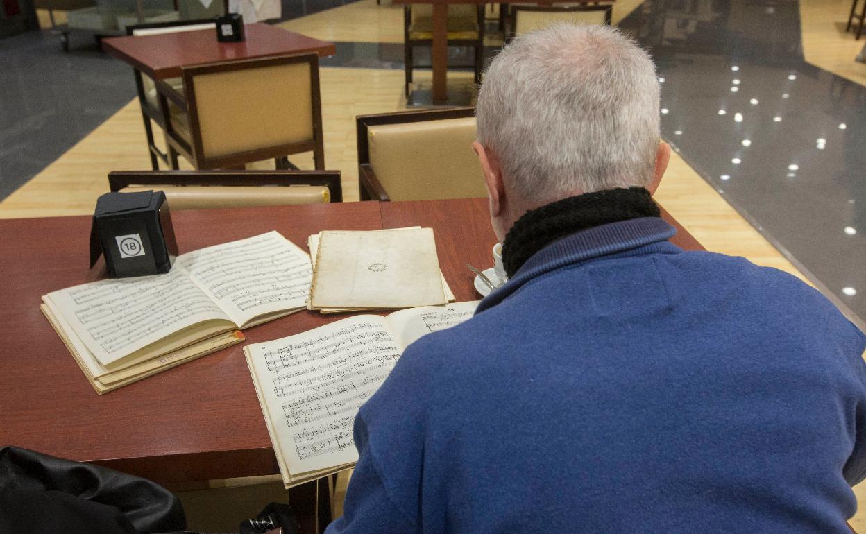 R. D., profesor de música, revisa partituras en una cafetería de Valencia. 