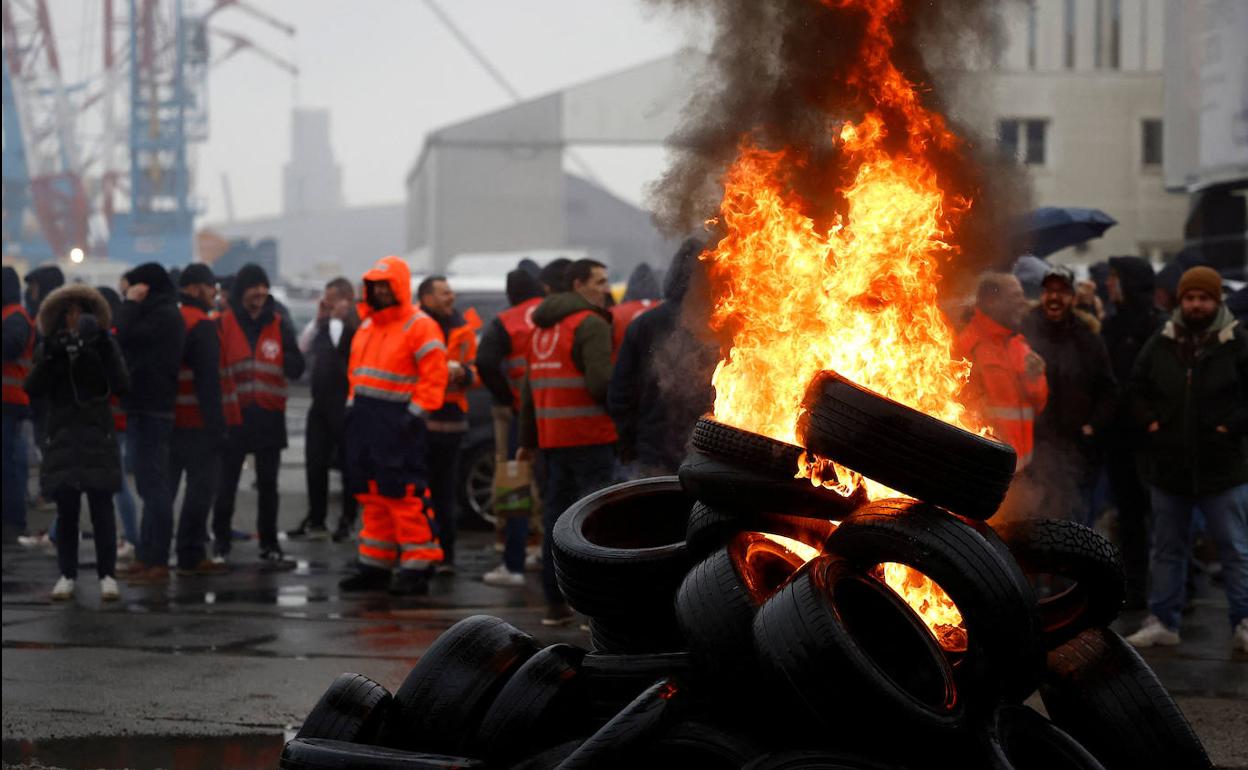 Trabajadores de la refinería ubicada en el puerto de Saint-Nazaire queman neumáticos. 