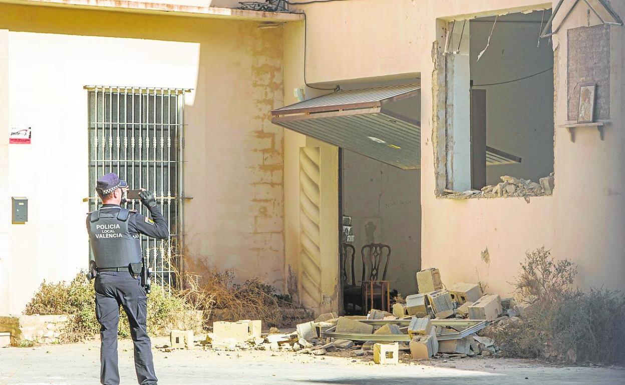 Un policía local fotografía la parte derribada de una nave el pasado diciembre. 