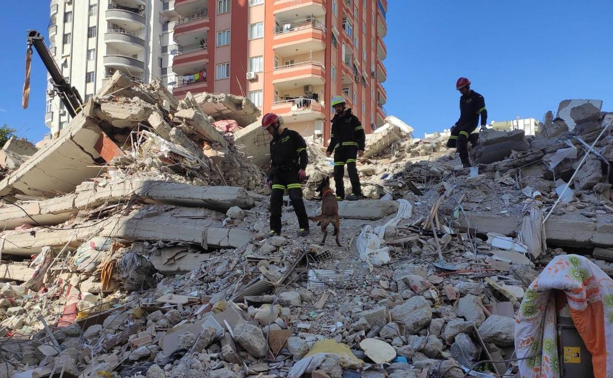 Los bomberos buscan a personas atrapadas entre los escombros en Turquía. 