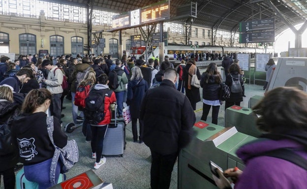 Cientos de personas esperan para subir al tren en la Estación del Norte de Valencia. 