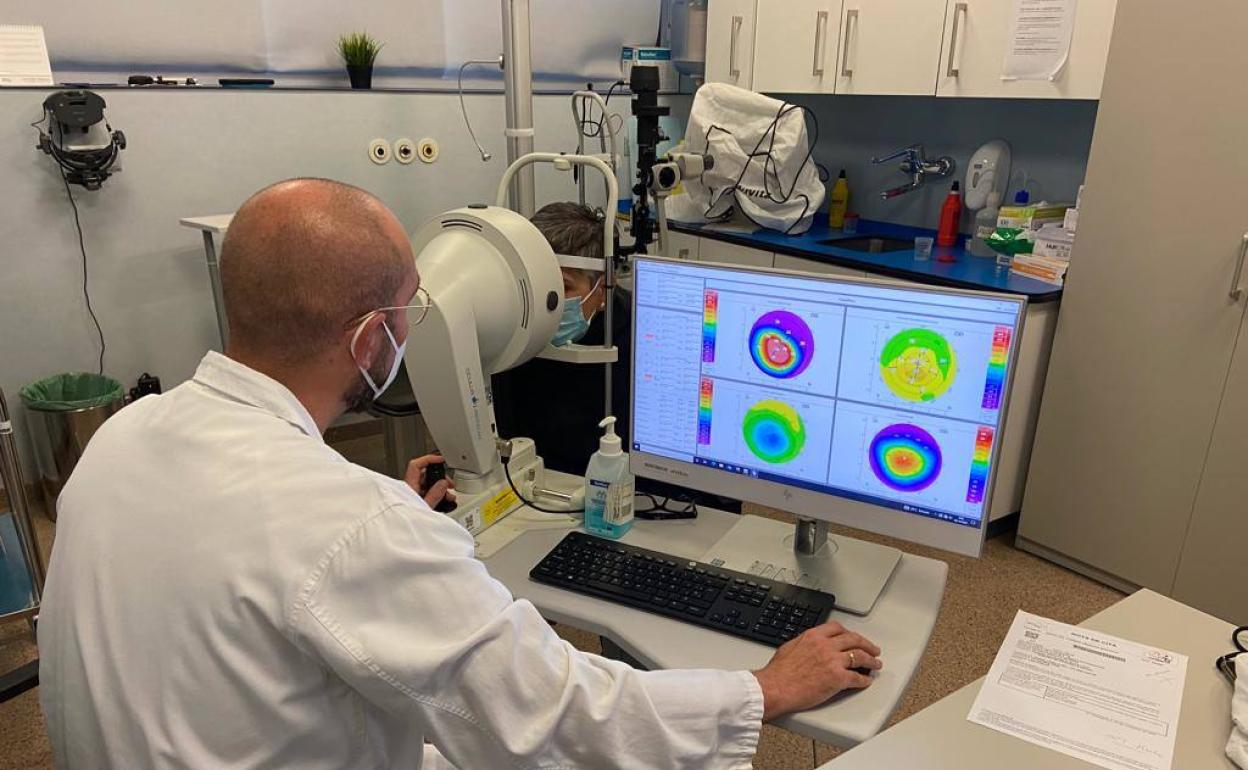 Un profesional realiza una tomografía corneal a un paciente en una consulta de Oftalmología.