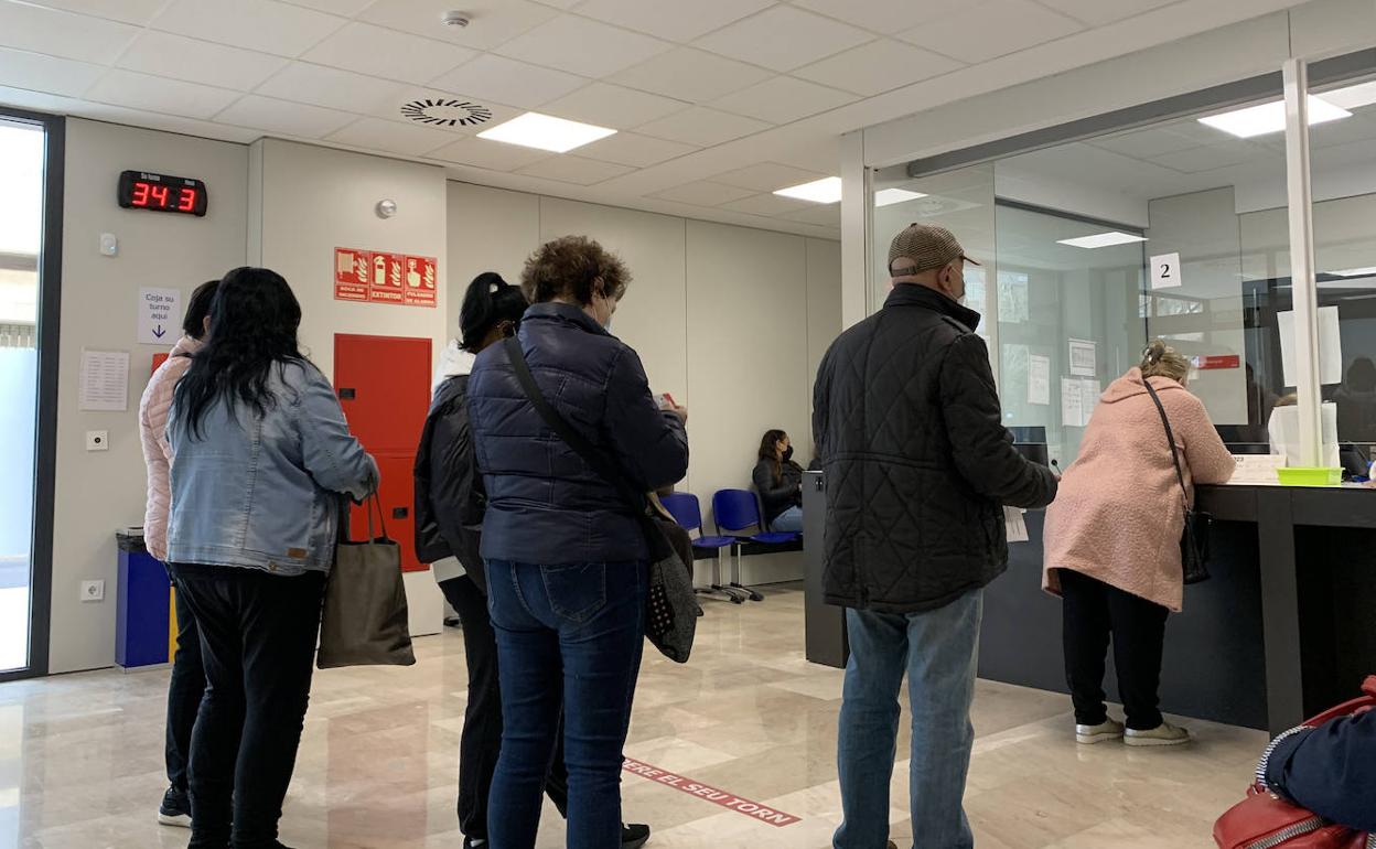 Pacientes hacen cola frente al mostrador de un centro de salud valenciano.