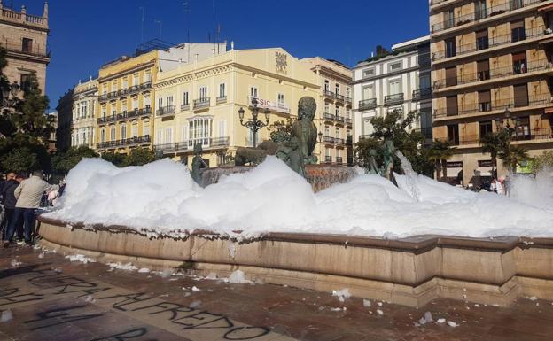 Llenan de espuma la fuente de la plaza de la Virgen de Valencia y pintan el suelo