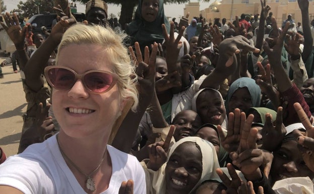 Imagen principal - Arriba, en Nigeria, cuando estuvo trabajando para Forbes África. Abajo, con su hermana gemela Fàtima. A la derecha, a punto de subir al helicóptero para contemplar Manhattan desde el aire.