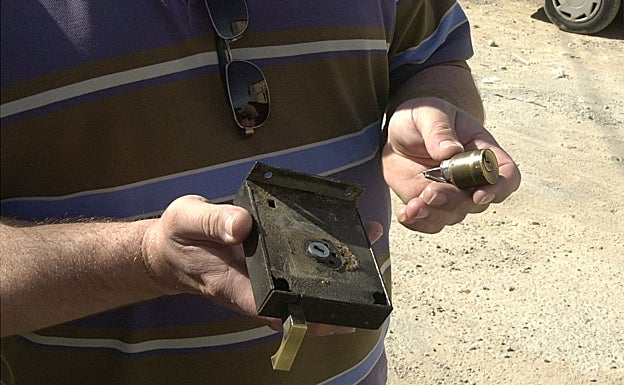 La víctima de un robo muestra la cerradura forzada por los ladrones. 
