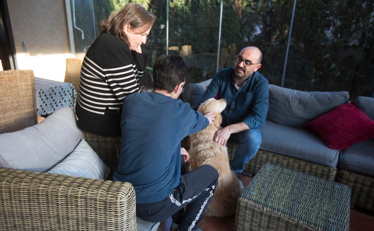 Ana y Jesús junto a Carlos, que acaricia a Leia, una de las mascotas de la familia. 