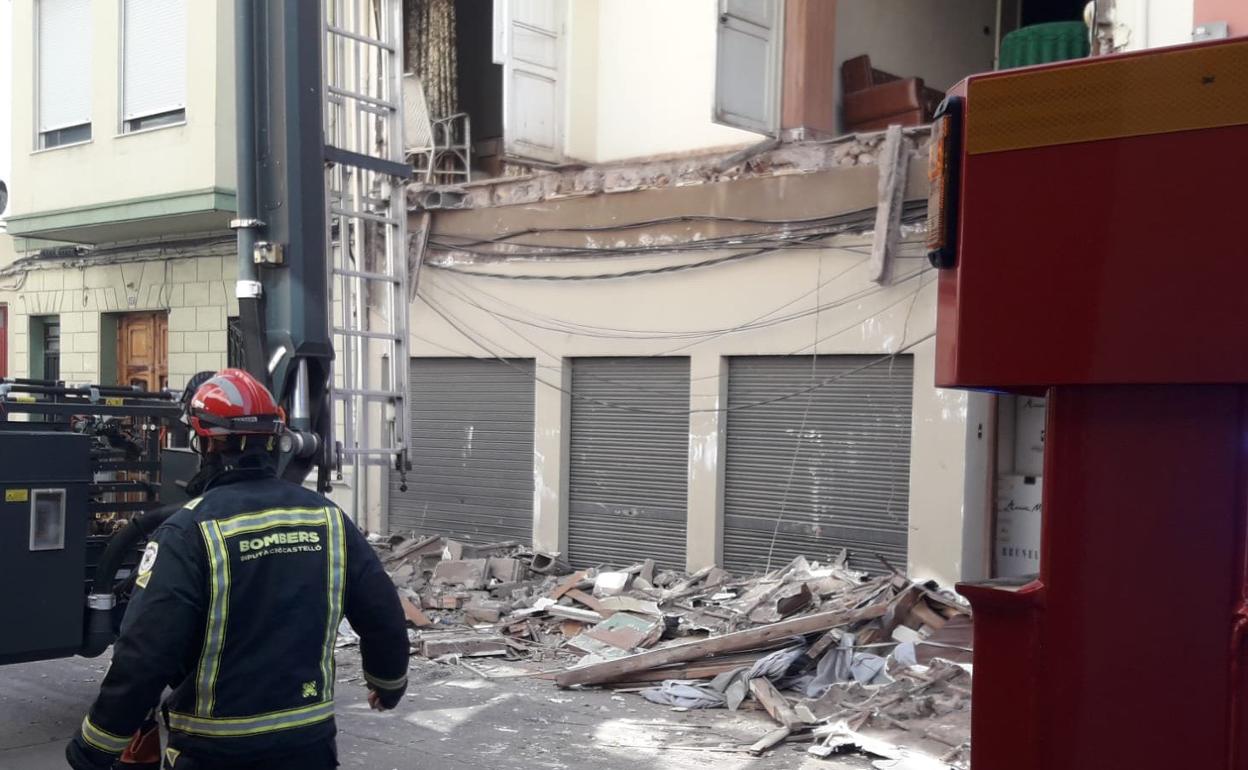 Un bombero del Consorcio de Castellón camina junto a los restos de los balcones desplomados