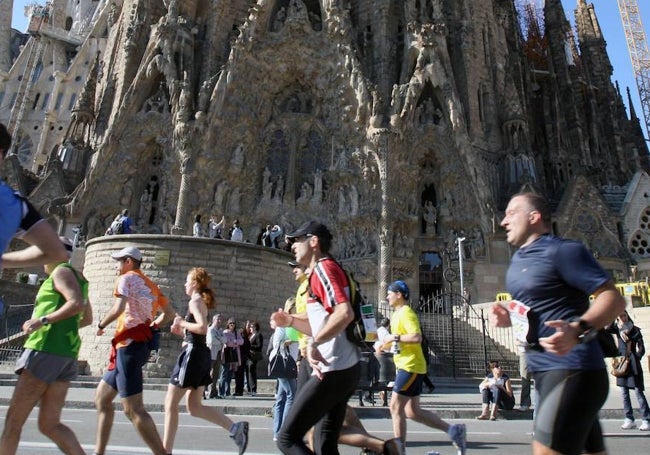 Participantes en el Maratón de Barcelona a su paso por la Sagrada Familia.