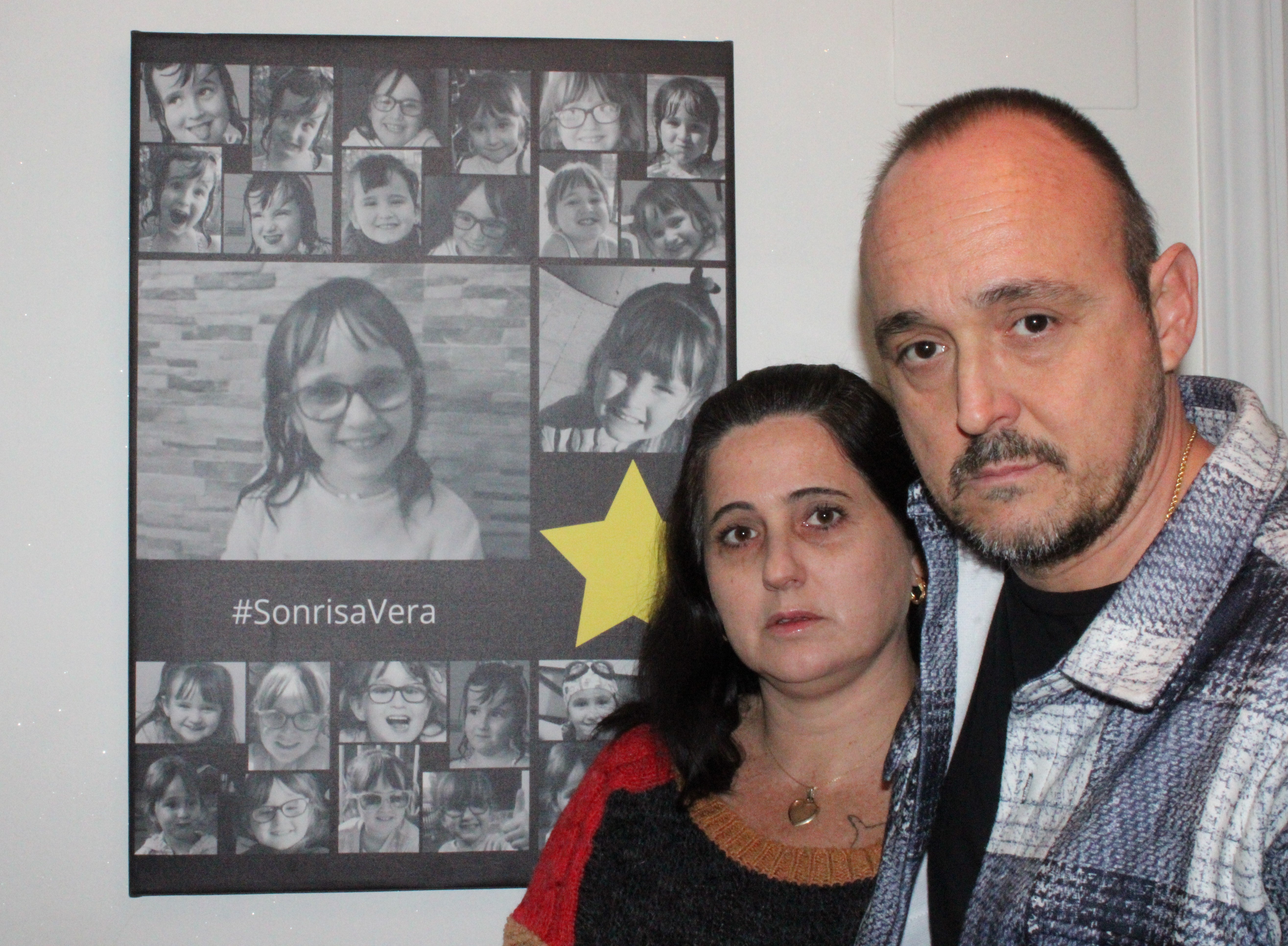 Eva e Iván, junto a un 'collage' formado por varias fotos de su pequeña Vera que preside una de las habitaciones de su casa.