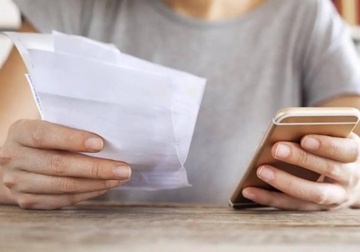 Una mujer consulta el móvil en una imagen de archivo