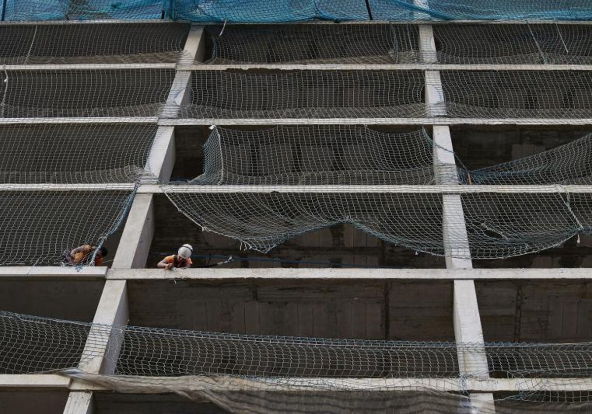 Dos obreros trabajan en un edificio en construcción en Valencia.