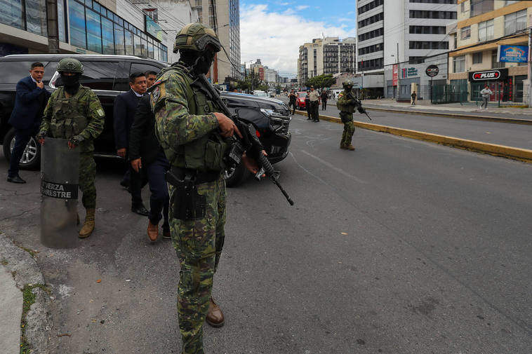 Militares custodian el vehículo que transporta al presidente de Ecuador, Daniel Noboa.