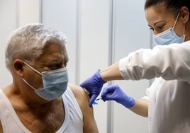 Una sanitaria vacuna a un hombre en Valencia.