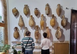 Dos visitantes admirando la muestra de ánforas del Museu Soler Blasco.