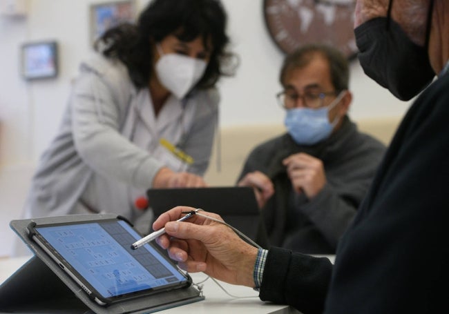 Dos pacientes de Alzheimer con una trabajadora en el centro de día de Benicalap.