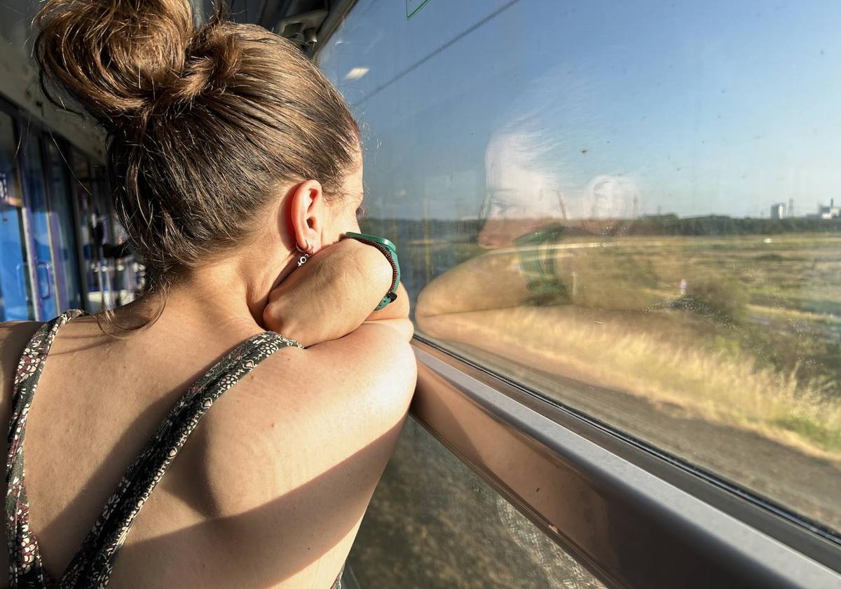 Una joven mira por la ventana durante un viaje en tren. Imagen de archjvo.