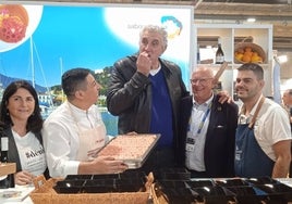 Romay, comiendo una gamba en el estand de Dénia.