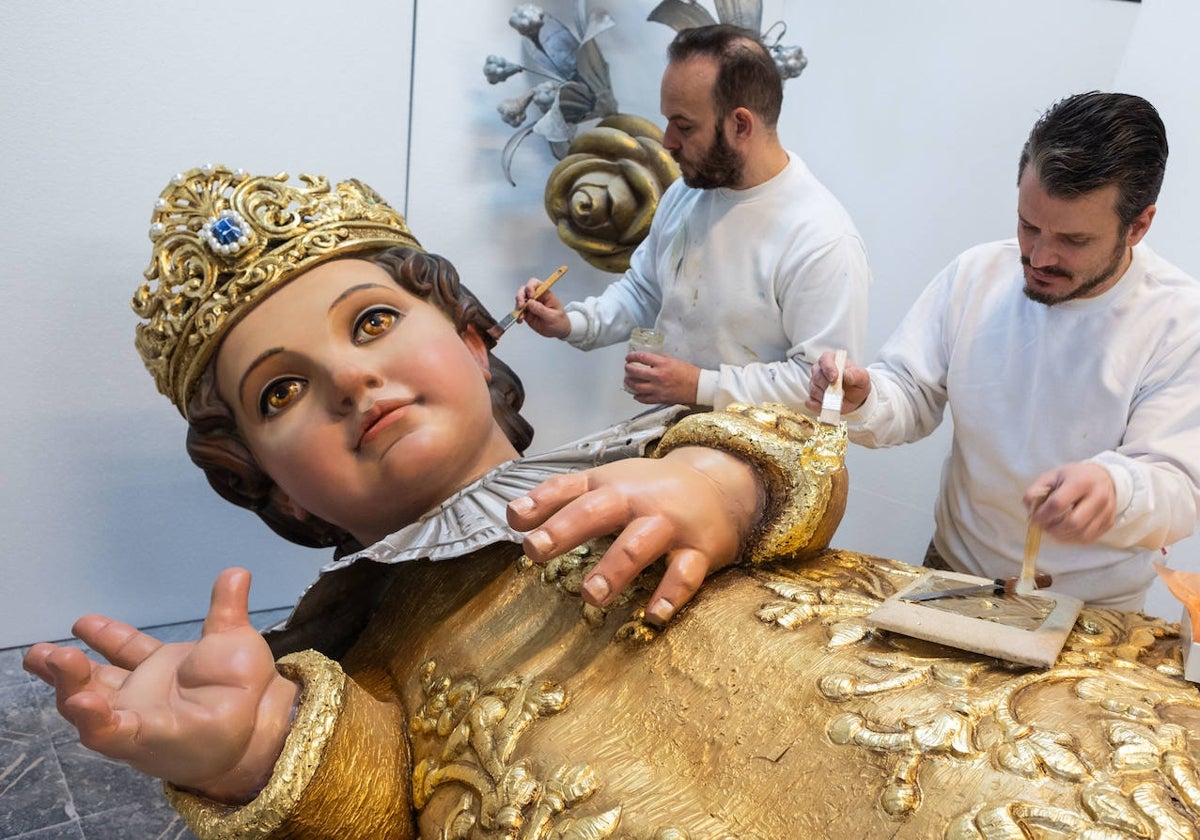 Los artistas José Luis Ceballos y Francisco Sanabria, en el proceso de restauración del Niño que forma parte del cadafal de la Virgen en la Ofreda.