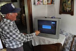 Un hombre intenta sintonizar un televisor.