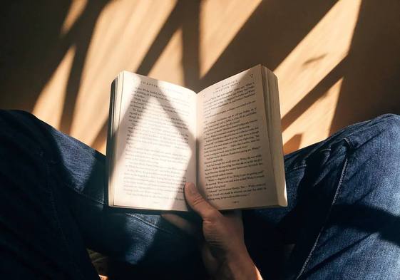 Una persona sostiene un libro con la mano.