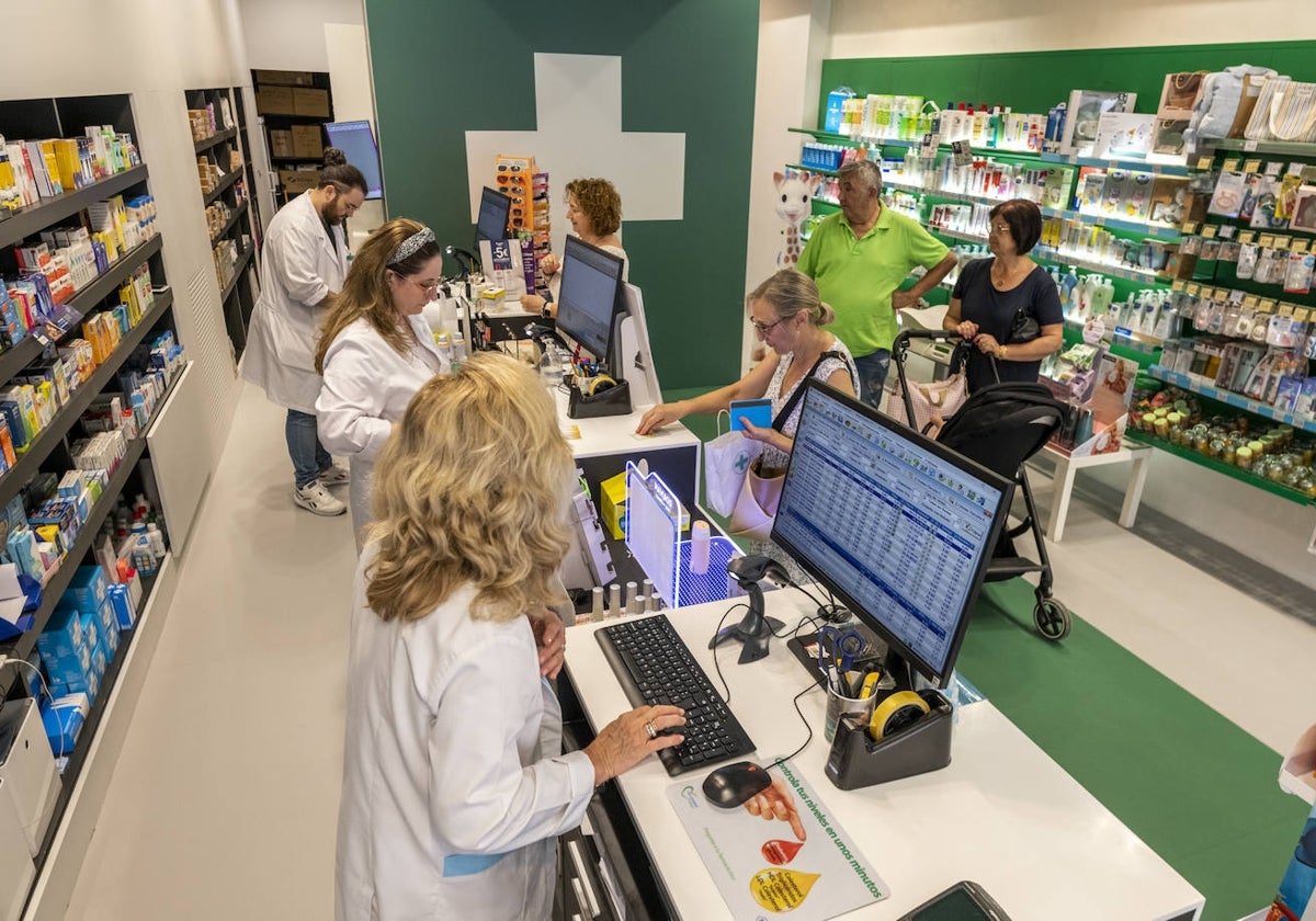 Farmacéuticos atienden a clientes en un establecimiento.