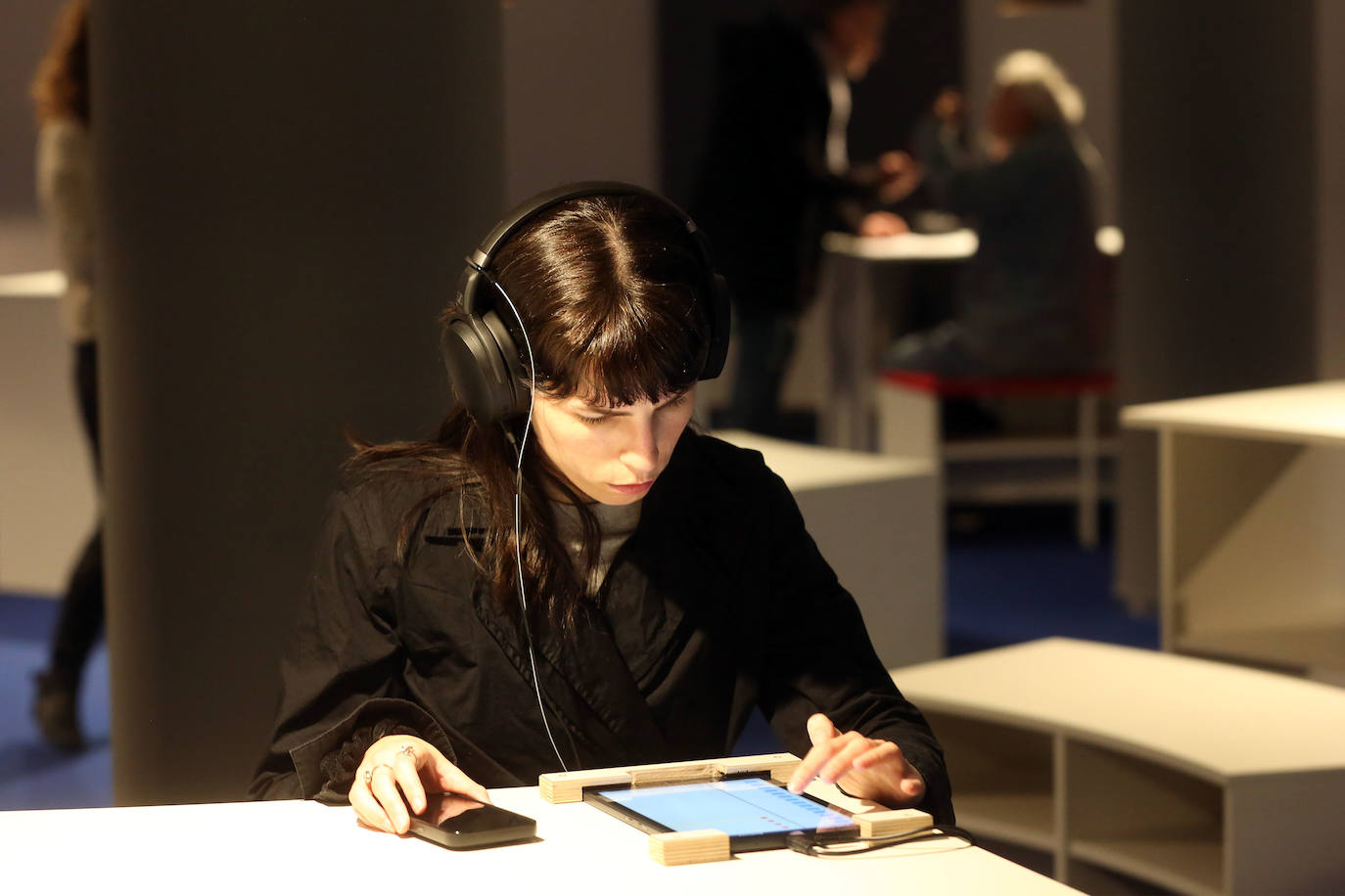 Una mujer contempla las piezas digitalizadas..