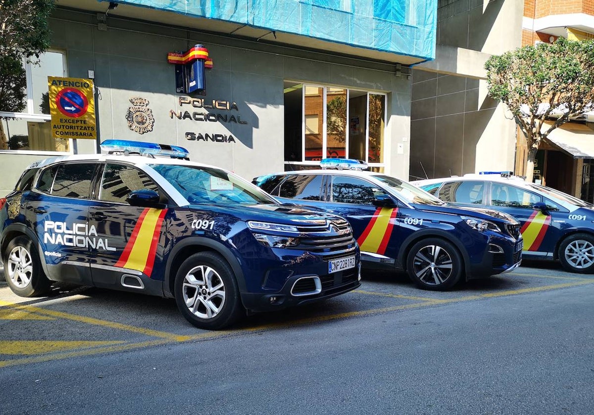 Varios vehículos de la Policía Nacional en la entrada de la comisaría de Gandia.