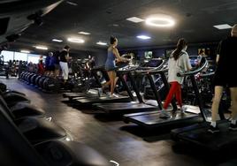 Varias personas de todas las edades haciendo deporte en un gimnasio.