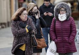 Tres mujeres protegidas contra el viento y el frio pasean por el centro de Valencia en una imagen de archivo.