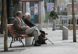 Dos personas mayores sentadas en un banco.