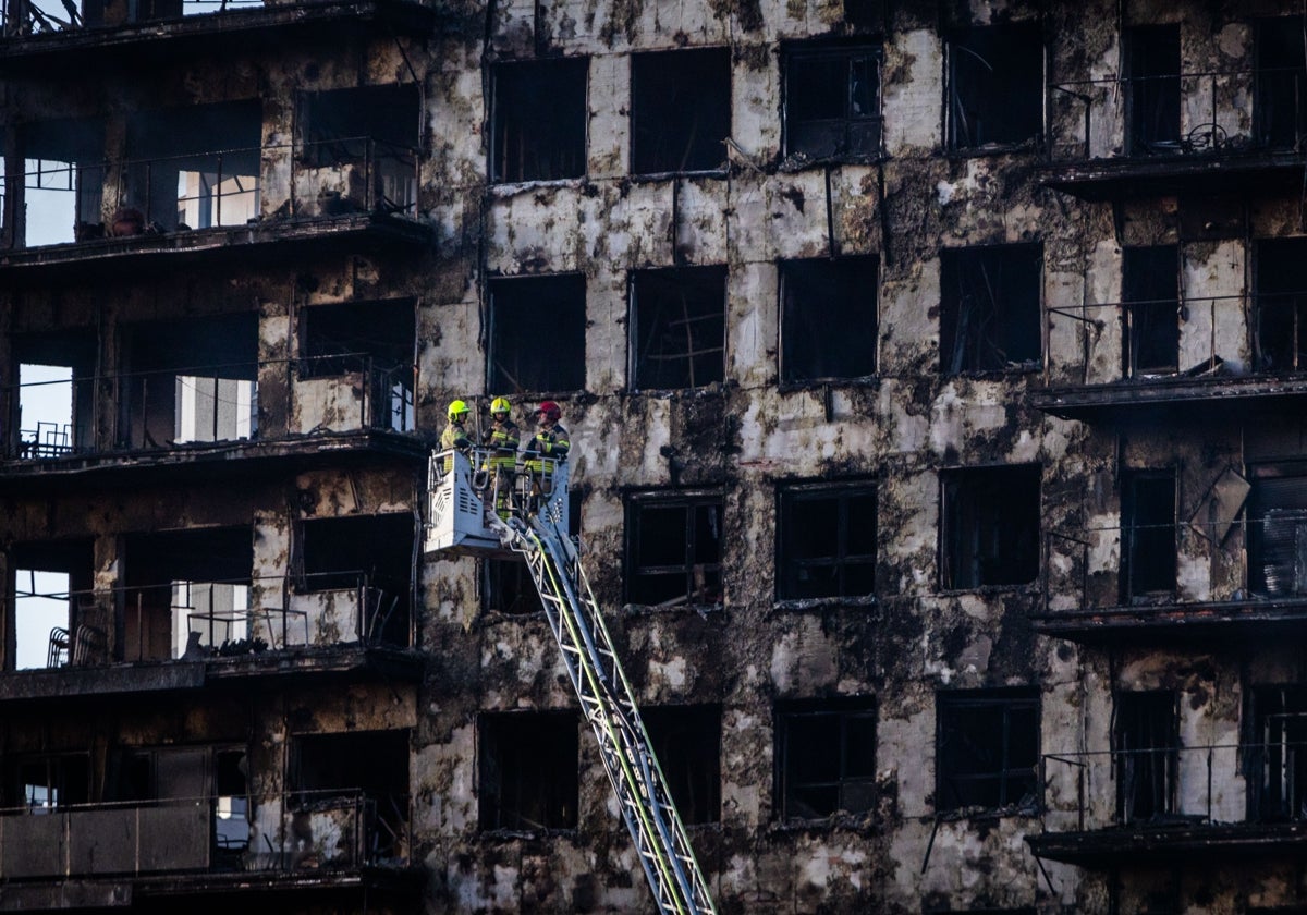 Un bombero actúa esta mañana en la fachada del edificio.