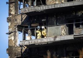 Los bomberos entran en el edificio calcinado.