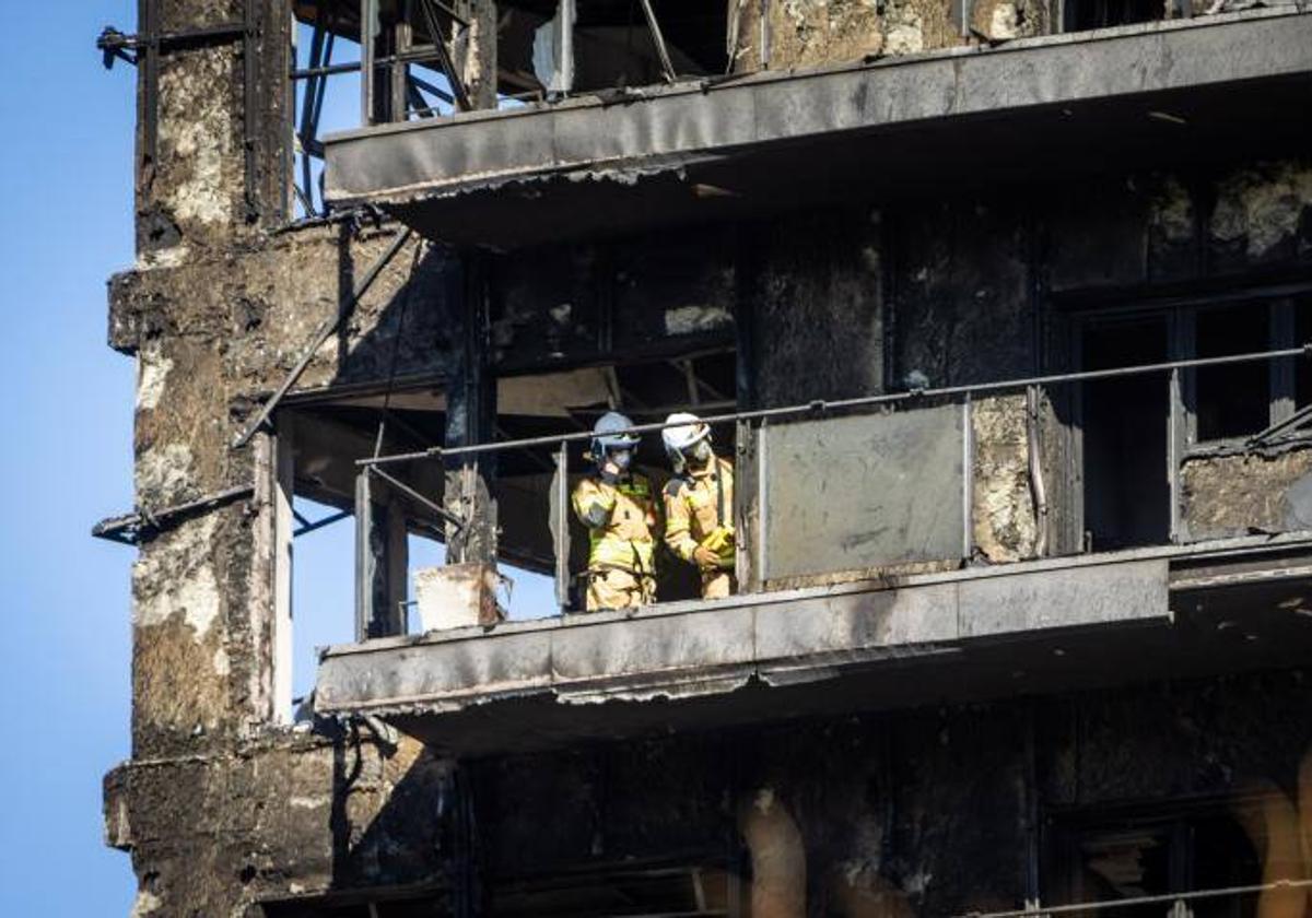 Los bomberos entran en el edificio calcinado.